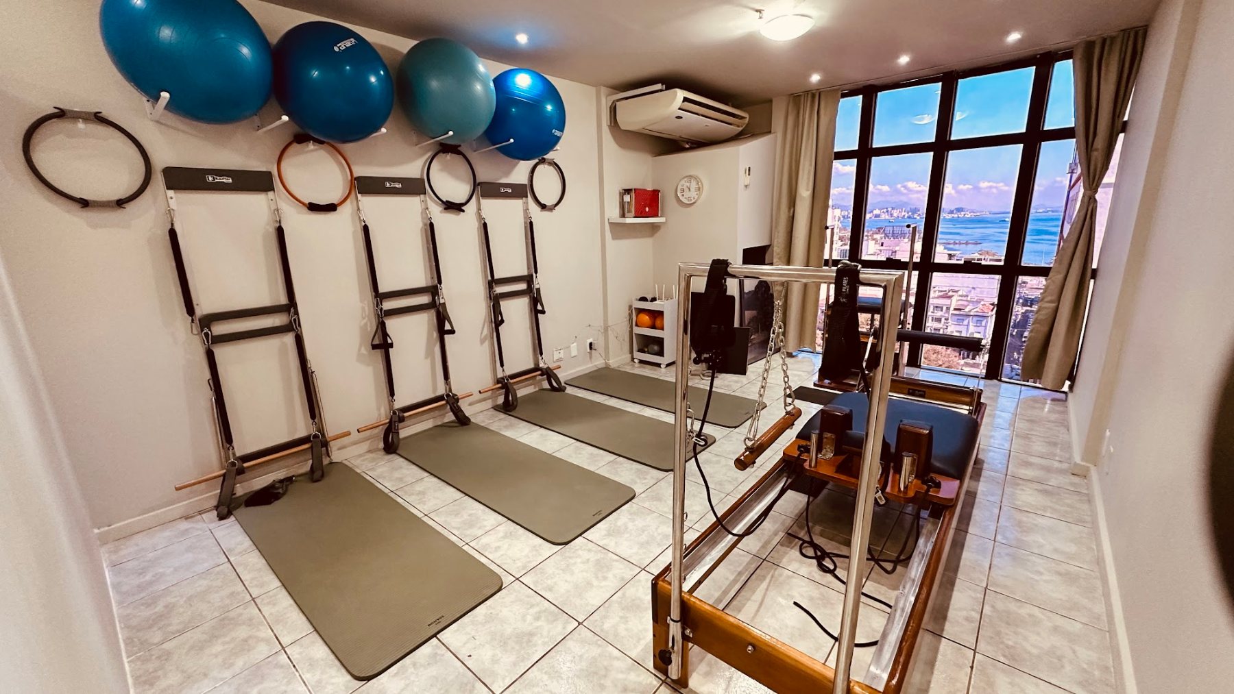 Estúdio Fisioequilíbrio com aparelhos de Pilates e janela ampla